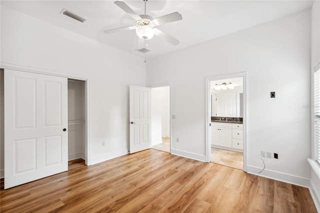 unfurnished bedroom with visible vents, connected bathroom, baseboards, light wood-style flooring, and a closet