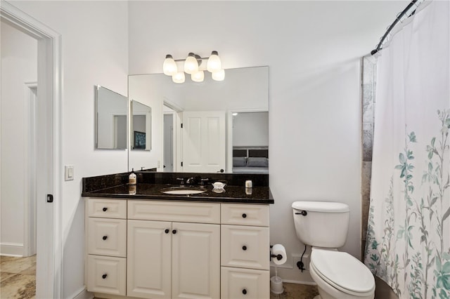 bathroom with vanity, toilet, a shower with curtain, and baseboards