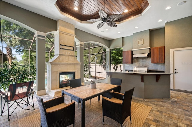 dining area with recessed lighting, wooden ceiling, a ceiling fan, and a tray ceiling