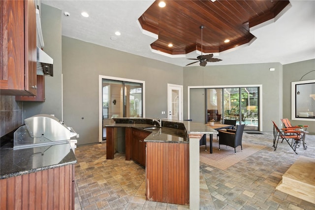 kitchen with a sink, a tray ceiling, recessed lighting, wooden ceiling, and ceiling fan