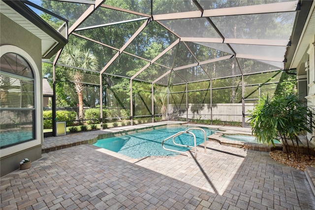 view of swimming pool with a fenced backyard, glass enclosure, a pool with connected hot tub, and a patio