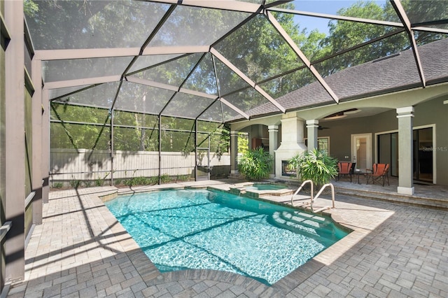 view of swimming pool featuring a patio area, a pool with connected hot tub, a lanai, and a ceiling fan