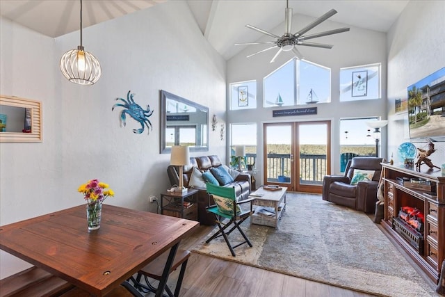 living area with high vaulted ceiling, wood finished floors, and a ceiling fan