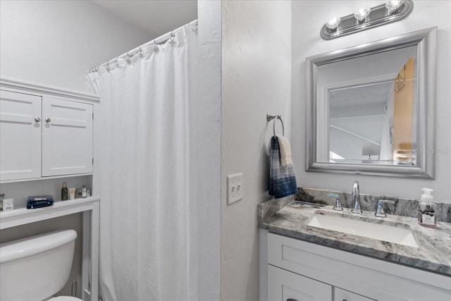 full bathroom featuring a shower with shower curtain, vanity, and toilet