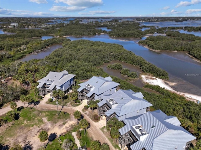 birds eye view of property featuring a water view and a wooded view