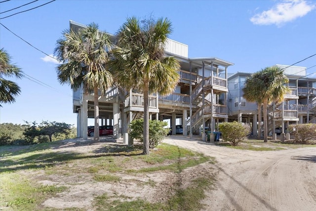 view of building exterior featuring a carport, stairway, and driveway