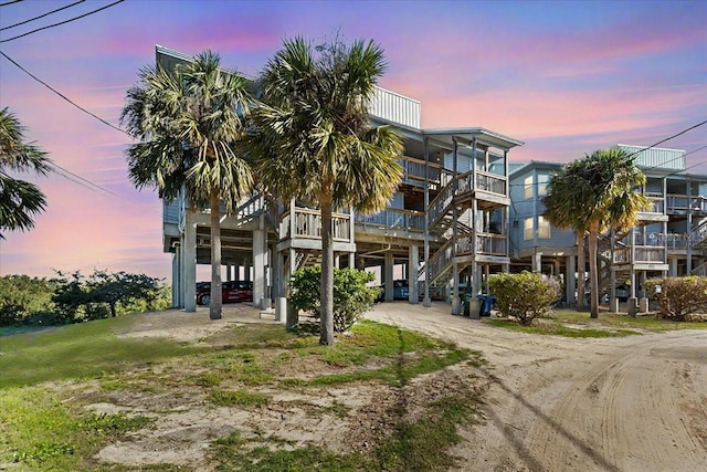 view of property with driveway, stairway, and a carport