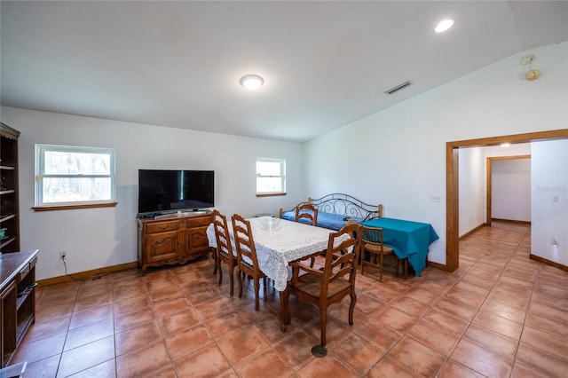 dining area featuring light tile patterned flooring, visible vents, baseboards, and lofted ceiling