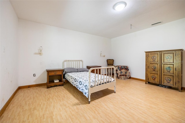 bedroom with light wood-style flooring, baseboards, and visible vents