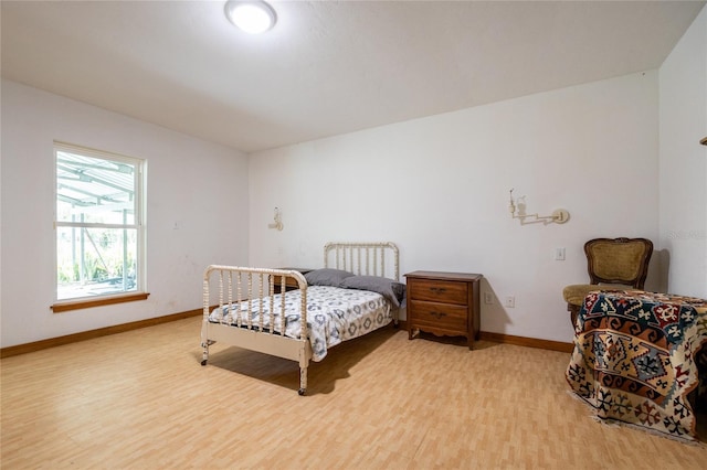 bedroom with light wood-style flooring and baseboards