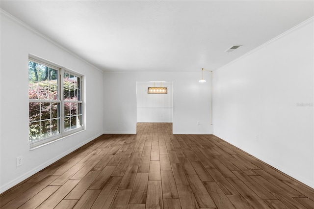 4031 NW 75th St, Gainesville, FL 32606 - spare room with visible vents, a chandelier, baseboards, ornamental molding, and wood finished floors