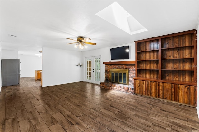 4031 NW 75th St, Gainesville, FL 32606 - unfurnished living room featuring a ceiling fan, a fireplace, a skylight, visible vents, and dark wood-type flooring
