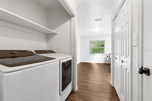 4031 NW 75th St, Gainesville, FL 32606 - laundry area with baseboards, separate washer and dryer, visible vents, and wood finish floors