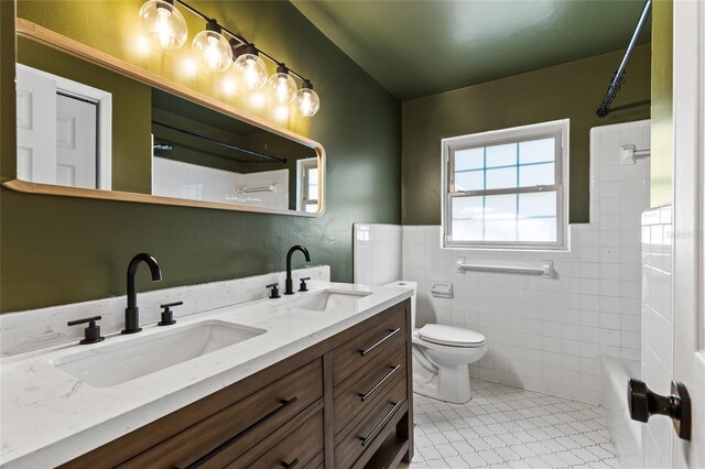 4031 NW 75th St, Gainesville, FL 32606 - bathroom with tile walls, toilet, double vanity, and a sink