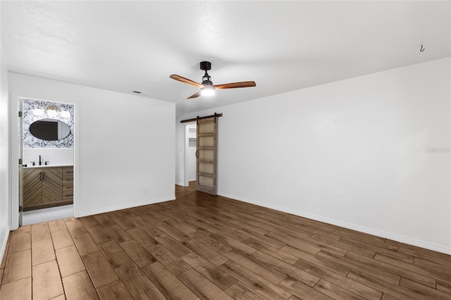4031 NW 75th St, Gainesville, FL 32606 - unfurnished room featuring visible vents, ceiling fan, wood finished floors, a barn door, and a sink