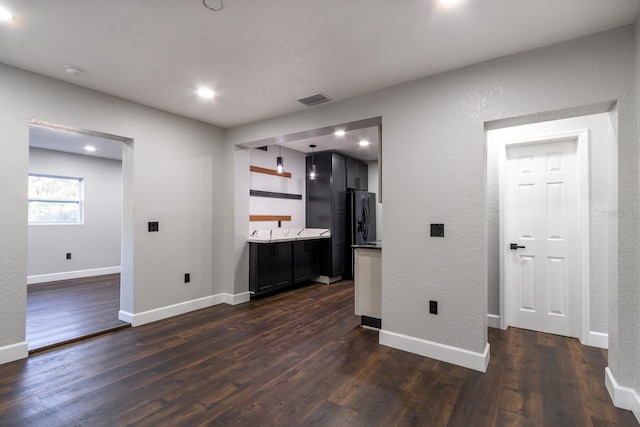 interior space featuring dark wood-type flooring, visible vents, baseboards, light countertops, and open shelves