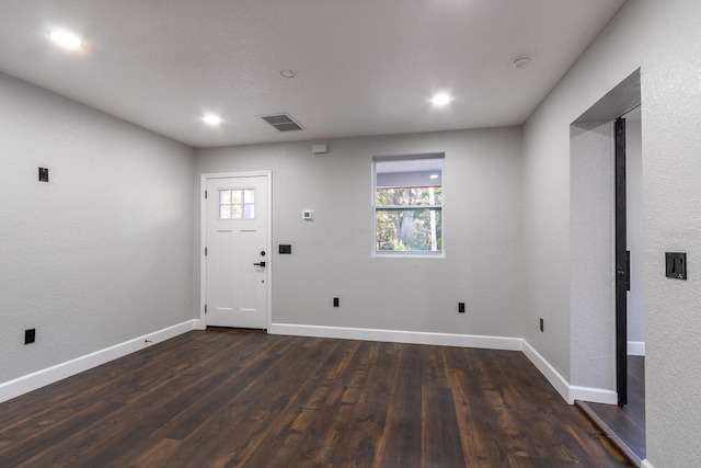 foyer entrance with dark wood-type flooring, visible vents, plenty of natural light, and baseboards