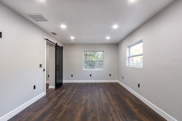 spare room featuring visible vents, baseboards, and a barn door