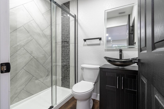 bathroom with a stall shower, vanity, and toilet