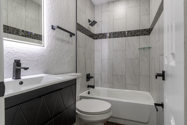 bathroom with toilet, a textured wall, vanity, and shower / tub combination