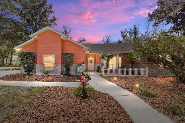 mid-century modern home with fence and brick siding