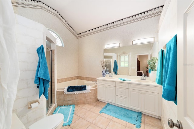 bathroom featuring double vanity, a stall shower, a sink, tile patterned flooring, and a bath