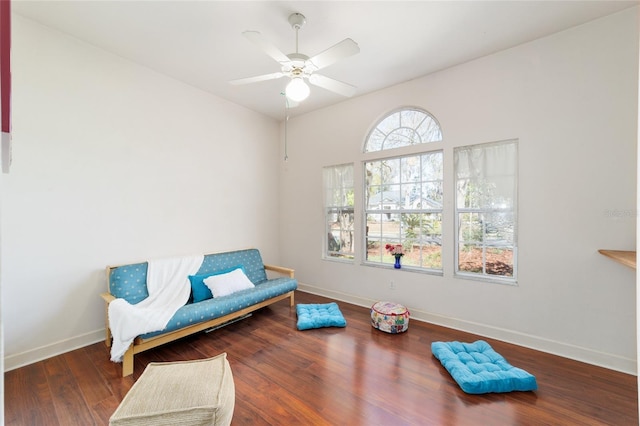 sitting room featuring wood finished floors, a ceiling fan, and baseboards