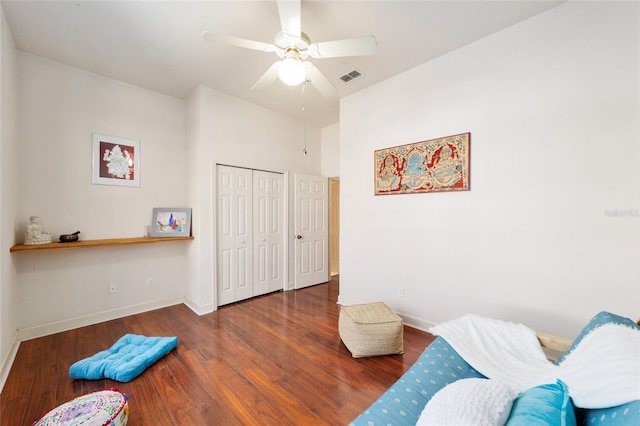 living area with a ceiling fan, baseboards, visible vents, and wood finished floors