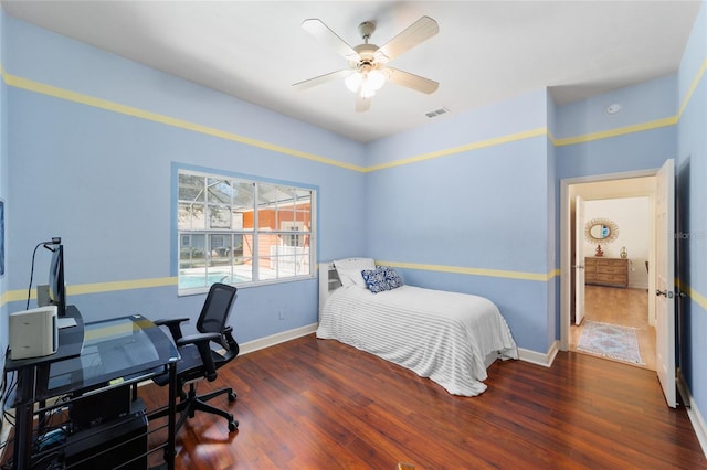 bedroom featuring a ceiling fan, wood finished floors, visible vents, and baseboards