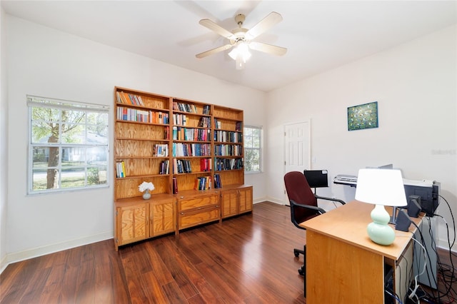 home office featuring dark wood-type flooring, a ceiling fan, and baseboards