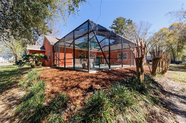 back of property featuring a patio, a lanai, and an outdoor pool