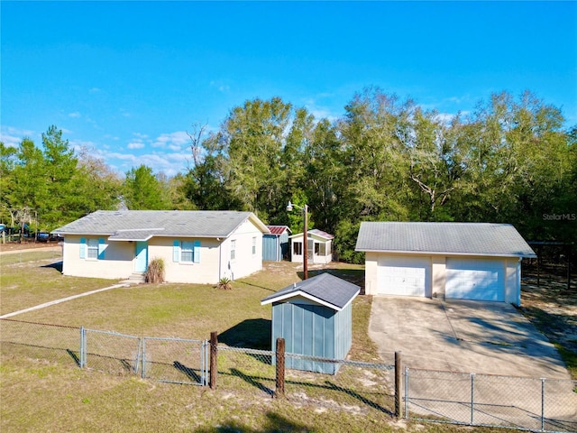 ranch-style home featuring an outbuilding, a gate, a detached garage, and a front yard