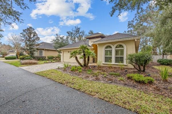 view of front of property with driveway, an attached garage, and stucco siding