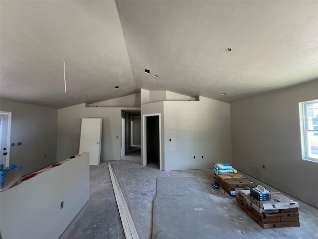 spare room with attic access and vaulted ceiling