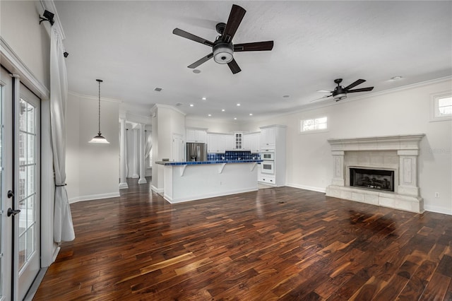 unfurnished living room with baseboards, a premium fireplace, ornamental molding, and dark wood finished floors