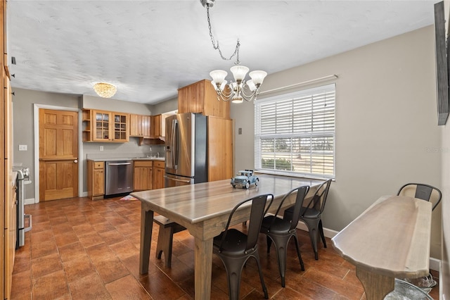 dining space with baseboards and a chandelier