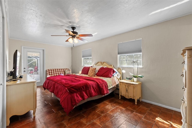 bedroom with a textured ceiling, a ceiling fan, access to exterior, and baseboards