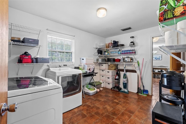 washroom with laundry area, visible vents, and washer and dryer