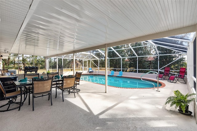 pool with glass enclosure and a patio area