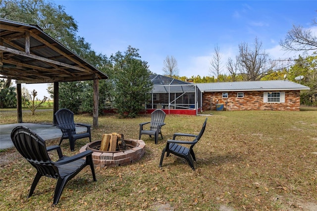 view of yard featuring glass enclosure and an outdoor fire pit