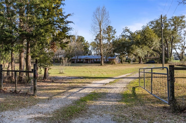 view of front of property featuring a gate, fence, and driveway