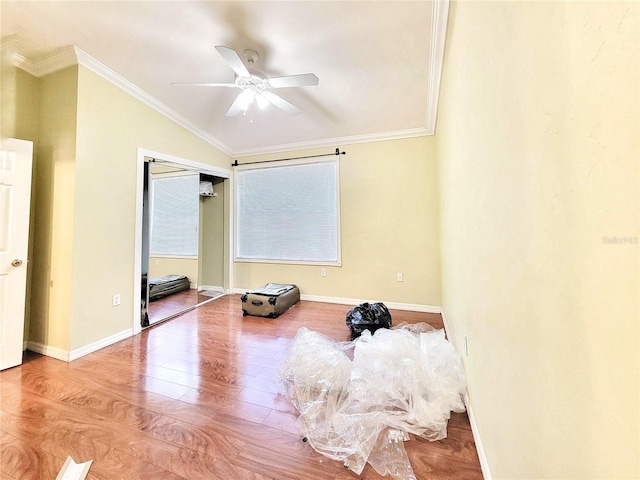 interior space featuring ornamental molding, baseboards, and wood finished floors