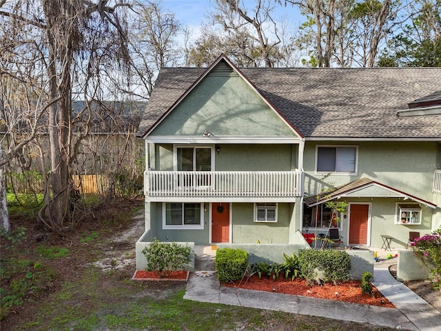 view of front of property featuring a shingled roof and stucco siding