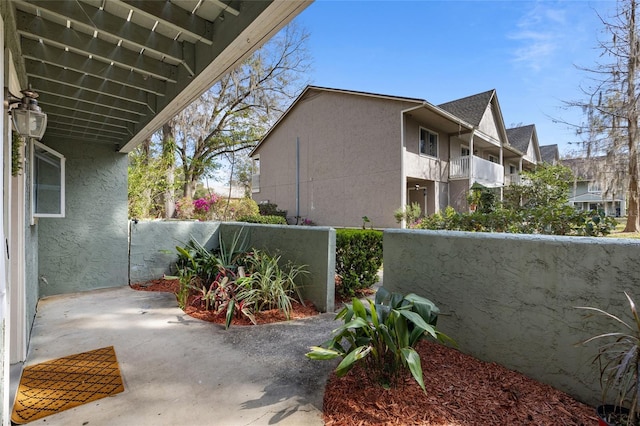 view of side of home featuring fence and stucco siding