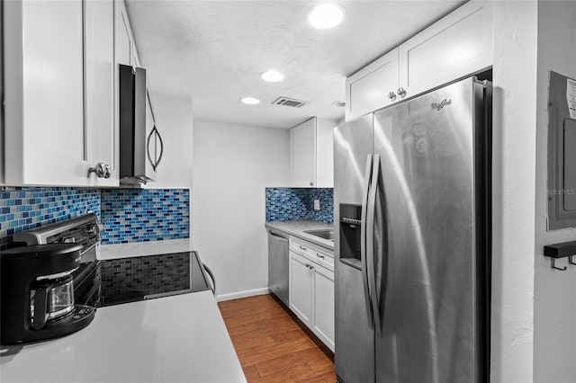 kitchen featuring appliances with stainless steel finishes, visible vents, dark wood finished floors, and white cabinetry