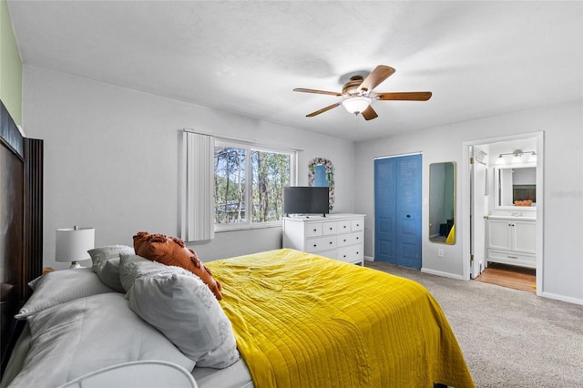 carpeted bedroom with connected bathroom, baseboards, and a ceiling fan