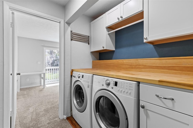 washroom featuring carpet flooring, washing machine and clothes dryer, cabinet space, and baseboards