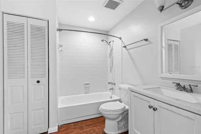 bathroom with visible vents, toilet, wood finished floors, vanity, and a closet