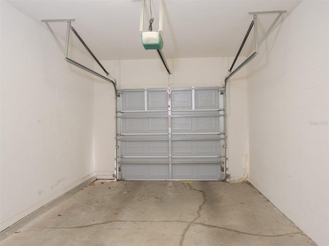 garage featuring concrete block wall and a garage door opener