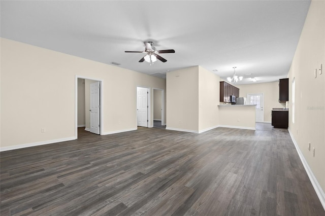 unfurnished living room with baseboards, dark wood-style flooring, and ceiling fan with notable chandelier